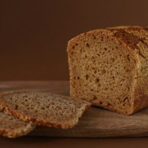 Bread loaf and slices on a wooden board.